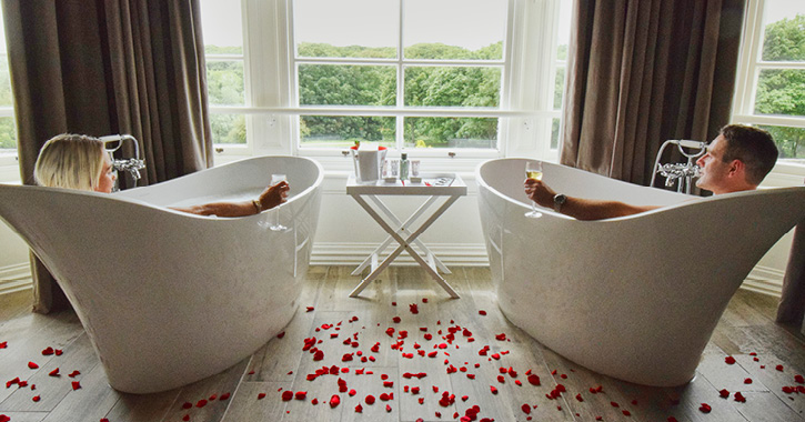 couple in bathtubs inside suite at Seaham Hall